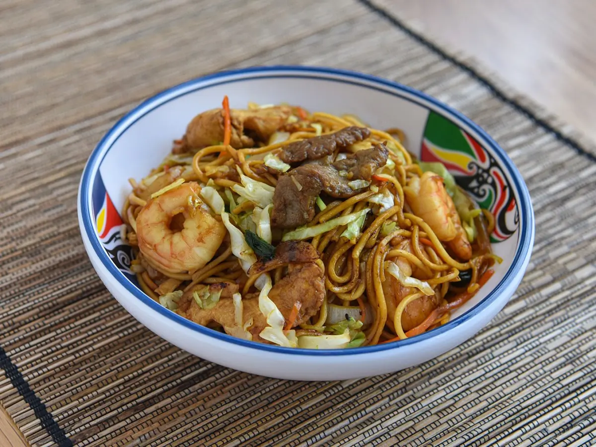 Seafood and Mixed Meat Fried Noodles are noodles stir - fried with shrimp, pieces of meat, cabbage, carrots, and other vegetables for a hearty dish at Dragon City, a Chinese restaurant in Albany